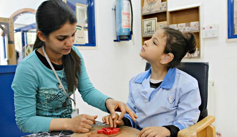 Maestra con estudiante reconociendo objetos con el tacto