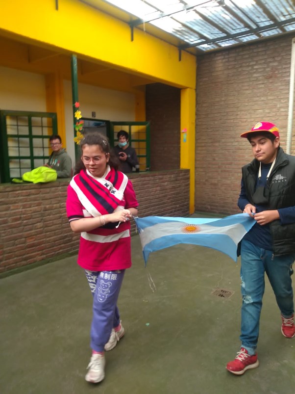 Lucia y un compañero por izar la bandera Argentina