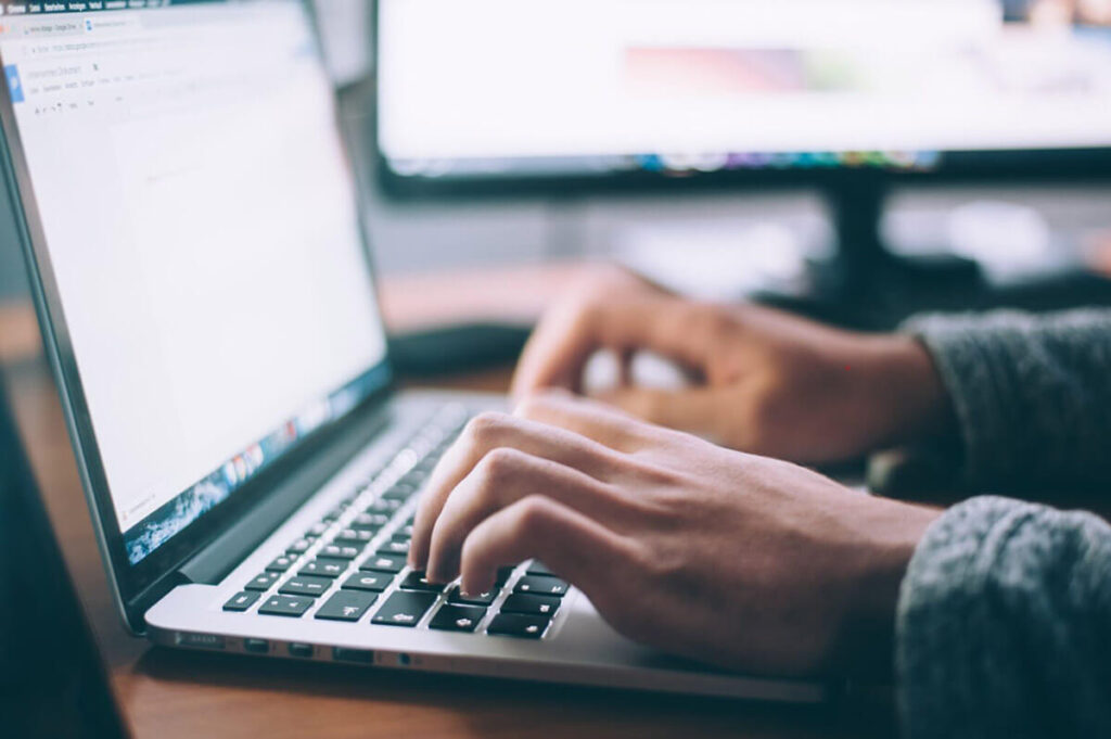 A person typing on a laptop computer