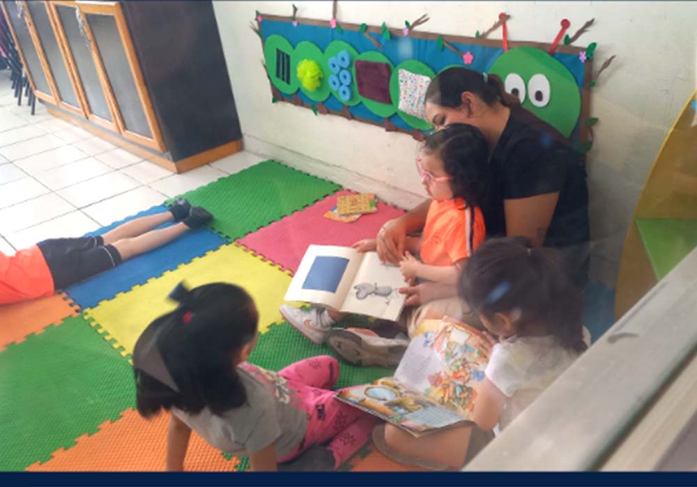 Maestra ayudando a un grupo de niños con ejercicios didacticos