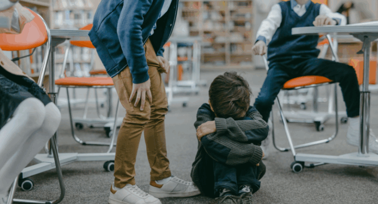 Varios adultos y niños pequeños se sientan sobre tapetes coloridos en una sala de juegos, participando en actividades de juego sensorial con diversos recipientes y materiales. Al fondo, se ven estantes con juguetes y materiales.
