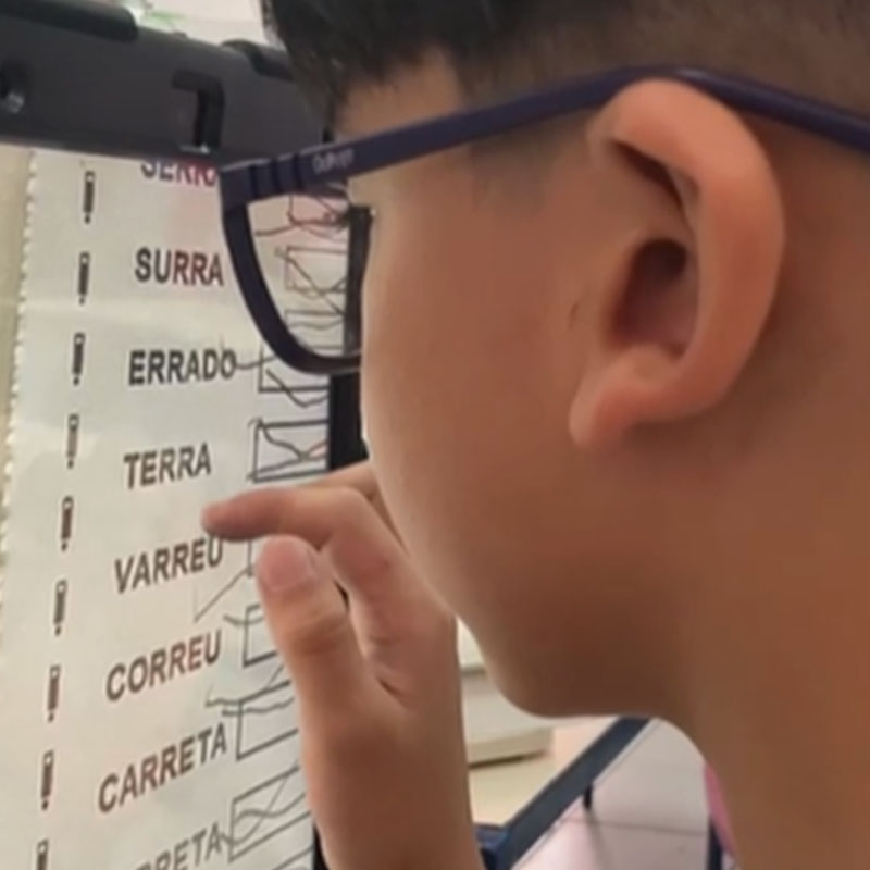 A criança seleciona opções de texto em uma tela.
