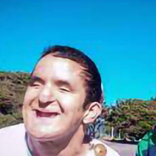 Samue vistiendo una remera clara y sonriendo. El fondo muestra un cielo azul y árboles verdes.